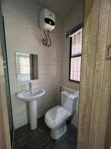a bathroom with a toilet and a sink at Oluyole Apartments Ibadan in Ibadan