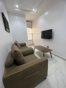 a living room with a couch and a table at Oluyole Apartments Ibadan in Ibadan