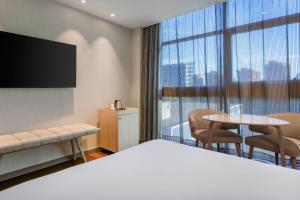 a hotel room with a bed and a tv and a table at AC Hotel Som by Marriott in Hospitalet de Llobregat