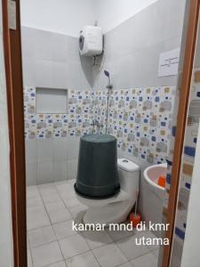 uma casa de banho com um WC com um tanque verde em Villa Brastagi Gunung Mas em Berastagi