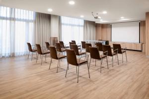 a conference room with chairs and a white screen at AC Hotel Som by Marriott in Hospitalet de Llobregat