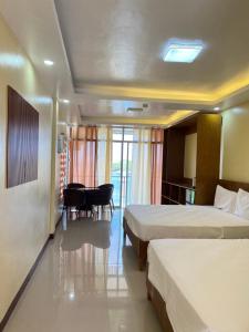 ein Hotelzimmer mit 2 Betten und einem Tisch in der Unterkunft C View Resort in Sipalay