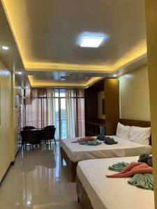 Habitación de hotel con 2 camas y mesa en C View Resort en Sipalay