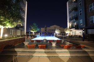 a courtyard with a fountain and benches at night at Heights Hacienda Hideaway in Houston