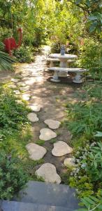 um caminho com uma mesa de piquenique e um banco num jardim em Chambres d'hôtes - Le Nador em Meurchin