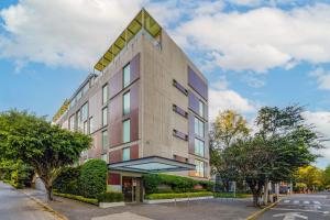 un edificio alto con un triángulo encima en City Express Suites by Marriott Anzures, en Ciudad de México