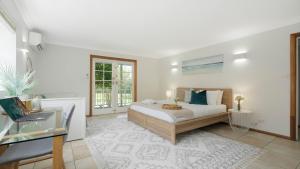 a bedroom with a bed and a desk and a window at Adelong in Kiama Downs