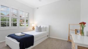 a white bedroom with a bed and two windows at Adelong in Kiama Downs +35 photos