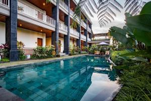 a swimming pool in the courtyard of a building at Paon Desa Ubud in Ubud