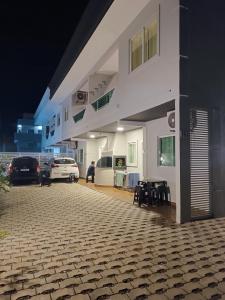 een wit gebouw met auto's geparkeerd op een parkeerplaats bij Residencial Brisa do Mar 2 in Bombinhas