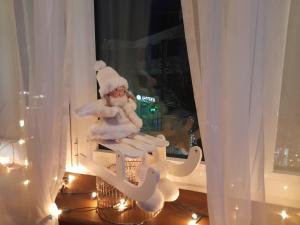 Un Babbo Natale seduto su una sedia in una finestra di Sibirska Central a Kolašin