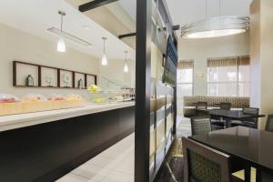 a restaurant with a counter and tables and chairs at SpringHill Suites by Marriott Oklahoma City Quail Springs in Oklahoma City