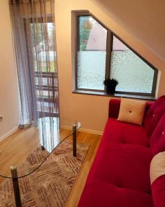 sala de estar con sofá rojo y mesa de cristal en Holiday home Ravna Planina en Pale