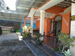una casa con paredes de color naranja y plantas en el patio en Villa RIJA By Nginep Villa en Tawangmangu