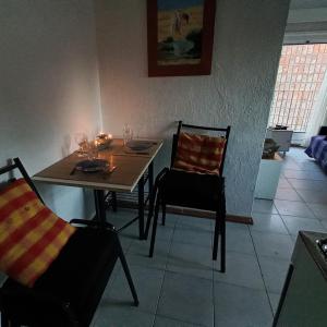 comedor con mesa y 2 sillas en Rambla Atlantida Villagio, en Atlántida