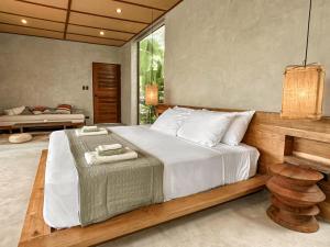 a bedroom with a large bed with white sheets at Kamaya - Private Villa with Pool in General Luna