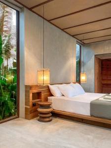 ゼネラル・ルナにあるKamaya - Private Villa with Poolのベッドルーム1室(ランプ2つ、窓付)