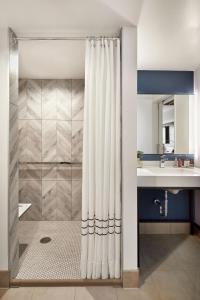 uma casa de banho com uma cortina de chuveiro e um lavatório em Anaheim Marriott em Anaheim