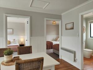 Zimmer mit einem Tisch und Stühlen sowie einem Schlafzimmer in der Unterkunft Unit 3 Little Banksia - A Perfect Base in Bicheno