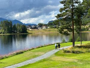 due persone che camminano lungo un sentiero vicino a un lago di Lakefront Villa, exclusive leisure property near Vrådal Golf, Straand Summerland & Panorama Ski center a Vrådal Altre 89 foto