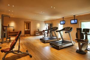 a gym with several treadmills and exercise bikes in a room at The Margi in Athens