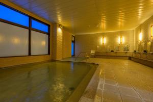 uma grande piscina de água num quarto grande em Hotel Edel Warme em Furano