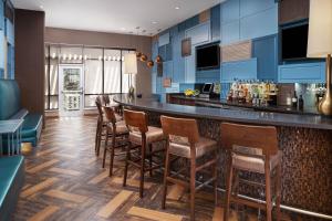 a kitchen with a bar with wooden stools at SpringHill Suites by Marriott Midland Odessa in Midland