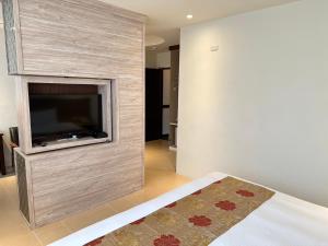 a living room with a flat screen tv on a wall at East Town 26 Hotel in Hualien City
