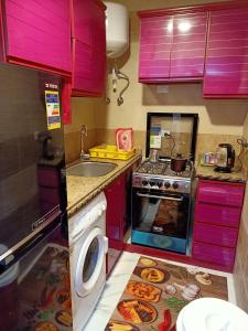 a kitchen with purple cabinets and a washing machine at A 5-star hotel room in front of Mansoura University in Mansoura