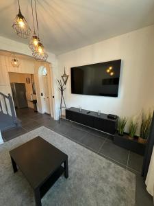 ein Wohnzimmer mit einem großen Flachbild-TV an der Wand in der Unterkunft Duplex avec extérieur privatif proche Paris/CDG in Livry-Gargan
