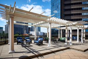 a white pergola with chairs and tables on a rooftop at Sheraton Hamilton Hotel in Hamilton