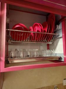 a shelf with red plates and glasses in a cabinet at A 5-star hotel room in front of Mansoura University in Mansoura