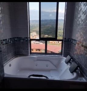 a bath tub in a bathroom with a window at Hotel Plaza Real Oiba in Oiba
