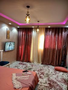 A 5-star hotel room in front of Mansoura University في المنصورة: غرفة نوم مع ستائر وسرير في غرفة