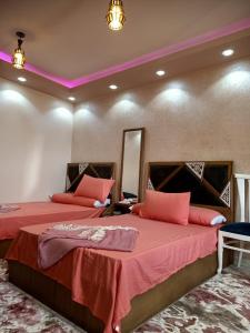 1 dormitorio con 2 camas con sábanas rojas en A 5-star hotel room in front of Mansoura University en Mansoura
