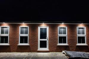een rood bakstenen gebouw met witte ramen in de nacht bij Large Annexe Sleep upto 8 in Windsor