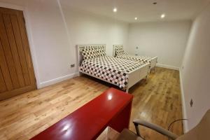 a bedroom with two beds and a wooden floor at Large Annexe Sleep upto 8 in Windsor