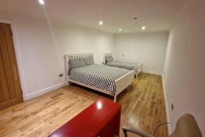 een kamer met 2 bedden en een houten vloer bij Large Annexe Sleep upto 8 in Windsor