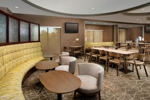 a restaurant with tables and chairs and a couch at SpringHill Suites by Marriott Jacksonville North I-95 Area in Jacksonville