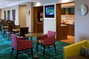 a restaurant with tables and chairs and a tv at SpringHill Suites by Marriott Lansing in Lansing