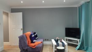 a living room with a chair and a tv at Peaceful and cosy apartment in Dorney