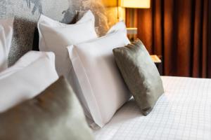 una cama con almohadas blancas encima en Mercure Urabandai Resort & Spa, en Kitashiobara