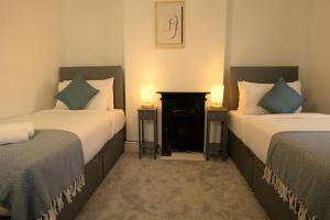 a hotel room with two beds and two lamps at Town Centre House with parking, Wi-Fi in Stafford