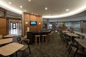a restaurant with a bar and tables and chairs at SpringHill Suites Ridgecrest in Ridgecrest