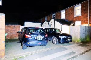 two cars parked in a parking lot at night at Town Centre House with parking, Wi-Fi in Stafford