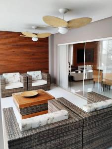 a living room with couches and a table at Casa alto padrão, Jd. Acapulco in Guarujá