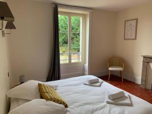 a bedroom with a white bed and a window at Grande maison familiale, 5 chambres, jardin, proche 24 Heures du Mans et abbaye de Solesmes. - FR-1-410-427 in Juigné-sur-Sarthe