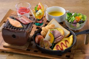 - une table en bois avec un plateau de nourriture et une assiette de nourriture gmaxwell gmaxwell gmaxwell dans l'établissement Hotel Edel Warme, à Furano