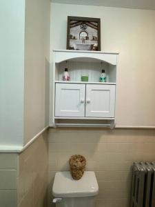 een badkamer met een witte kast boven een toilet bij House of the Heart at Trolley Square! in Wilmington