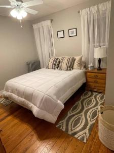 een slaapkamer met een groot bed en een dressoir met een plafondventilator bij House of the Heart at Trolley Square! in Wilmington